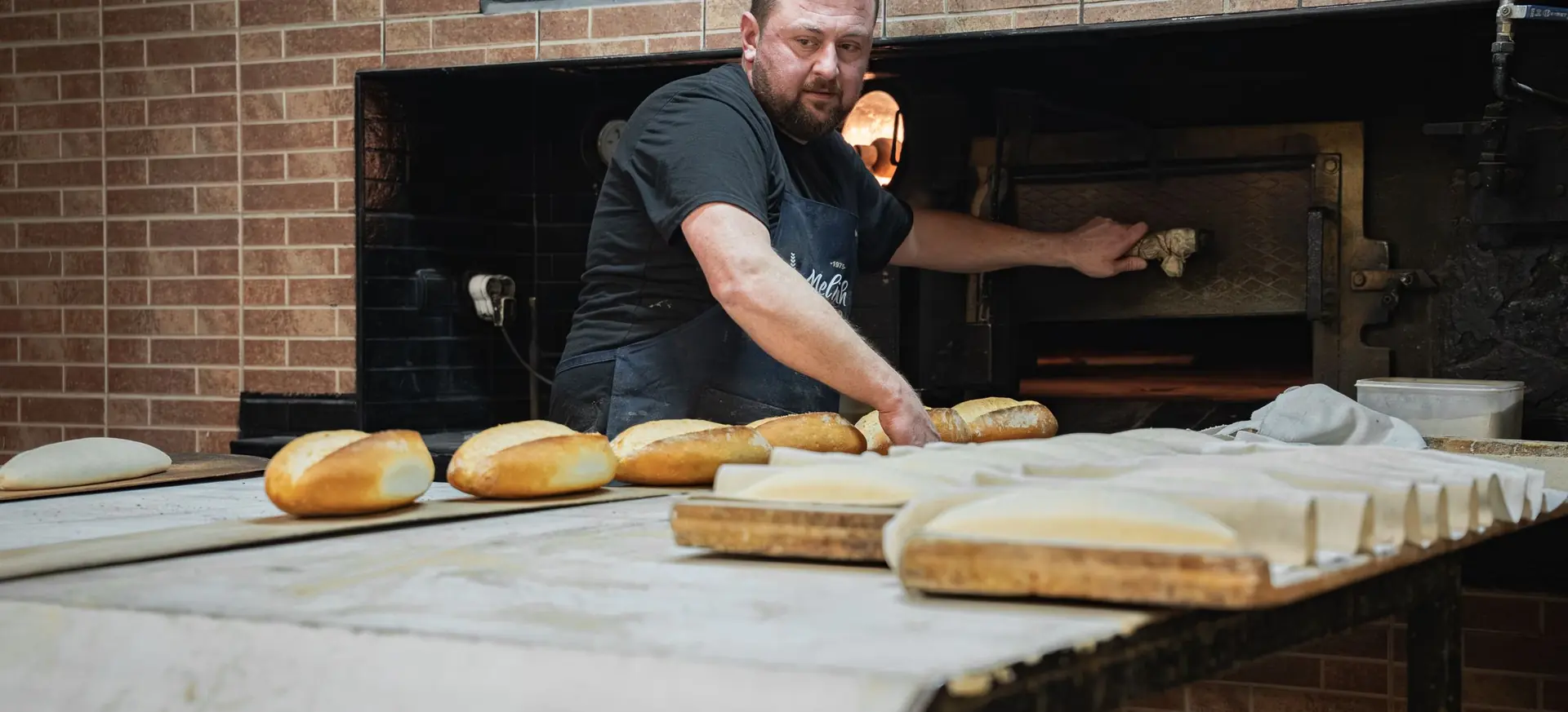 Boulanger enfournant des pains dans un four traditionnel